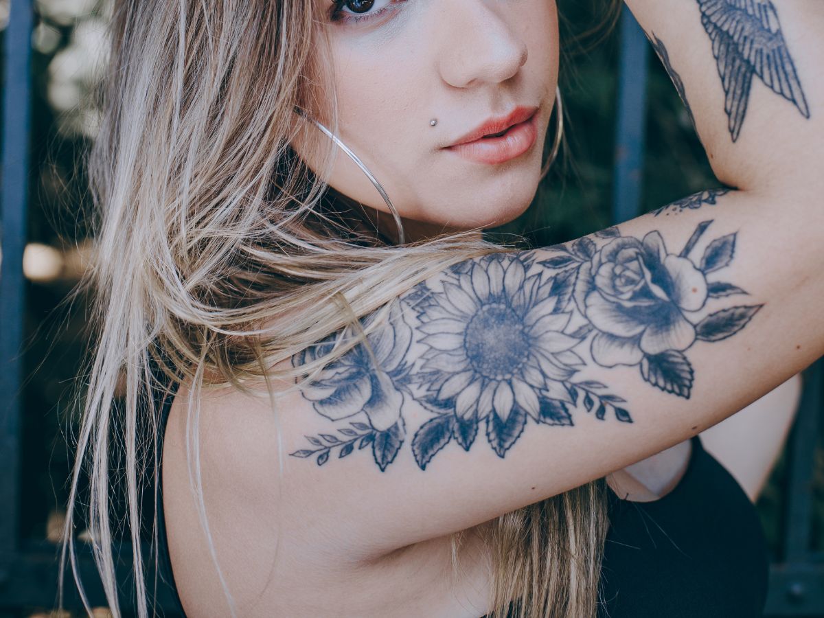 tatuagem feminina no braço arte de flor