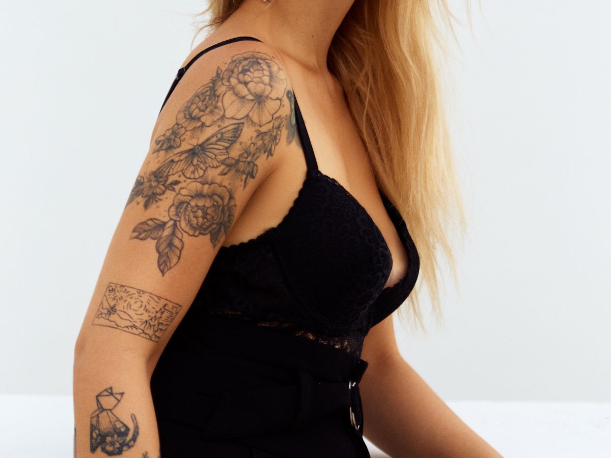 tatuagem feminina no braço flores, gato, desenho